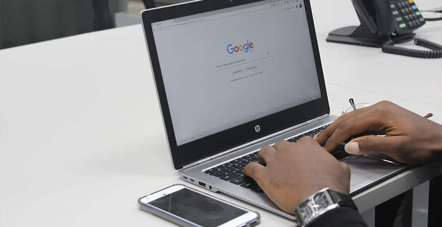 An image of a person typing something into the search bar on Google.com